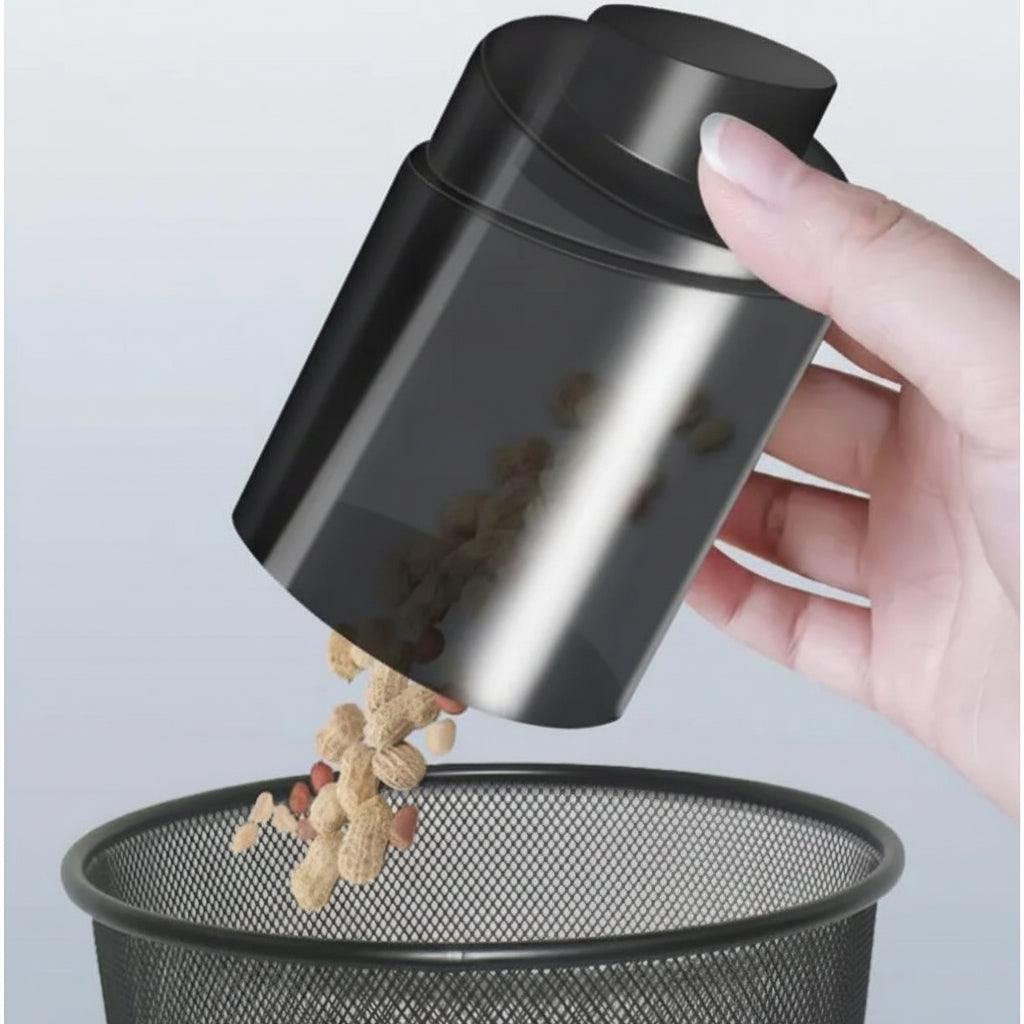 Black powder shaker being used to pour powder into a metal container on a light gray background
